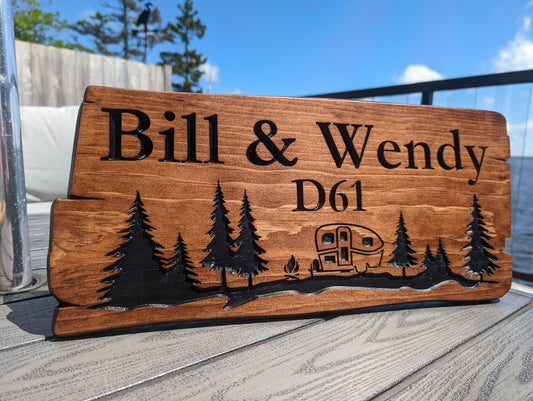 Custom engraved rustic wood address sign 'Bill & Wendy D61' with trees and house graphic. Personalized cabin plaque or home welcome sign for nature lovers.